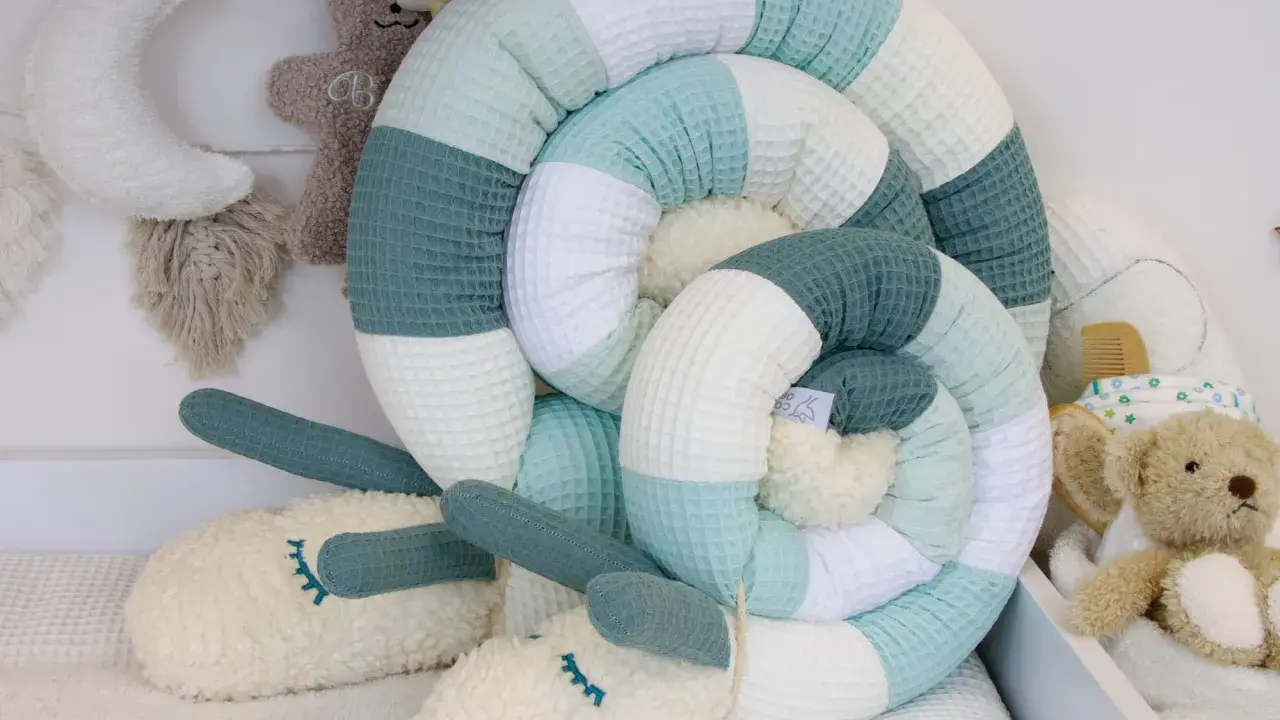 Ein kuscheliger Schnecken-Nestchen für das Babybett. Der cord waschen ist weich und in beruhigenden Pastelltönen gehalten.