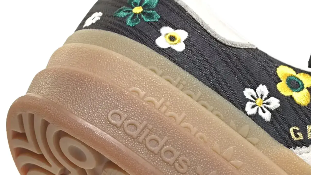Detailansicht eines adidas liberty Sneakers mit Blumenstickerei und Gummisohle.