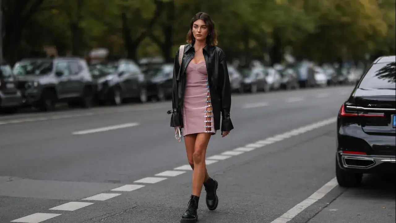 Frauen Dr. Martens richtig tragen: Ein stylisches Outfit mit rosa Kleid, Lederjacke und den ikonischen Boots.