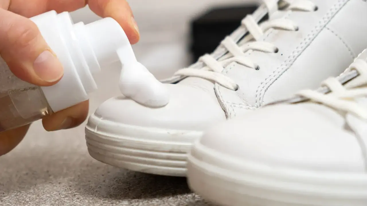 Schaum wird auf weiße Sneaker aufgetragen, um sie sauber zu machen.