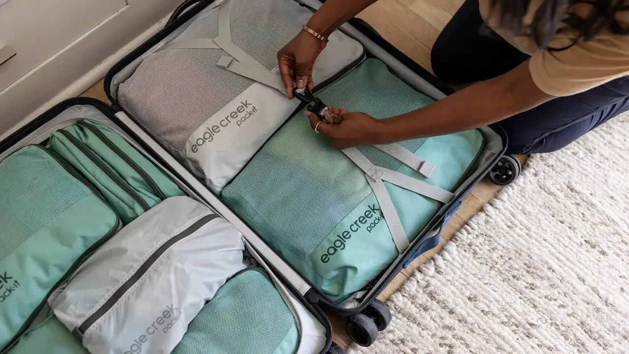 Frau packt ihren Koffer mit Packwürfeln. So packe ich meinen Koffer für die Reise, ordentlich und platzsparend.
