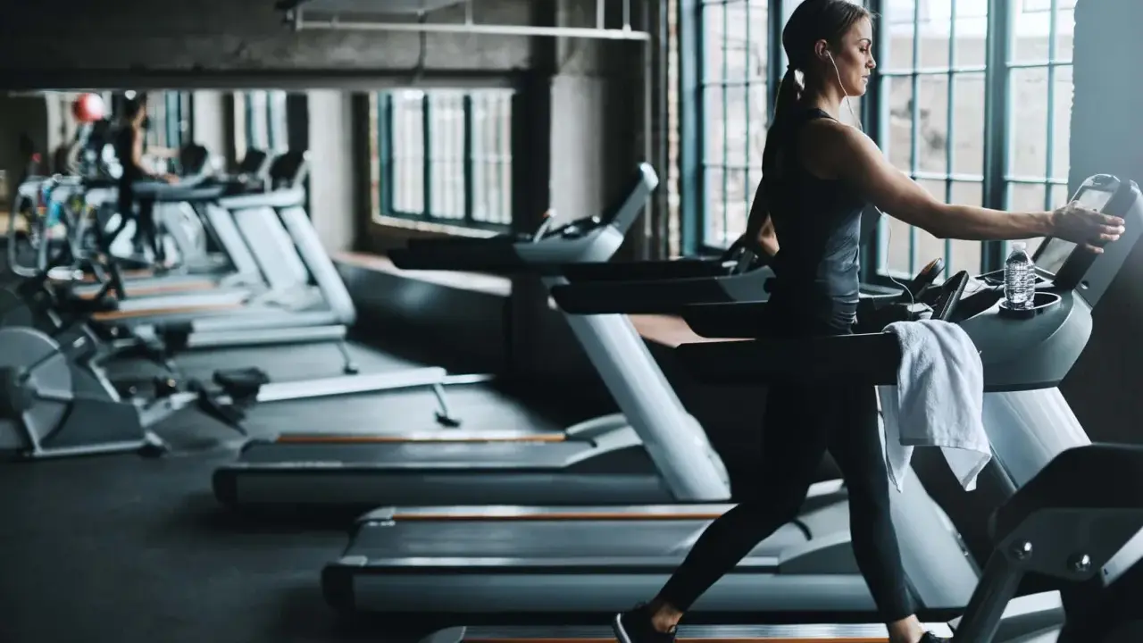 Frau läuft auf Laufband im Fitnessstudio. Ein Laufband bringt Ausdauer und Fitness.