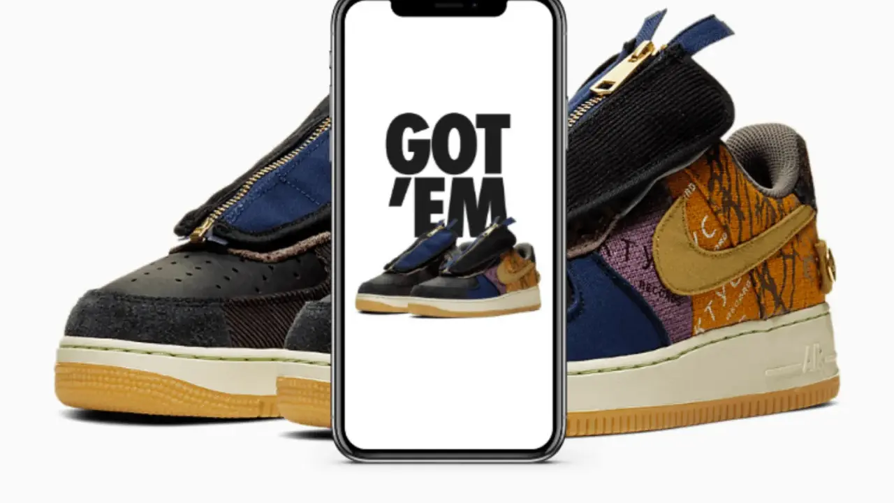 Ein Handy zeigt "GOT 'EM" über einem Paar Travis Scott Air Force 1. Das ist, was ist ein raffle, wenn man diese begehrten Sneaker ergattert!