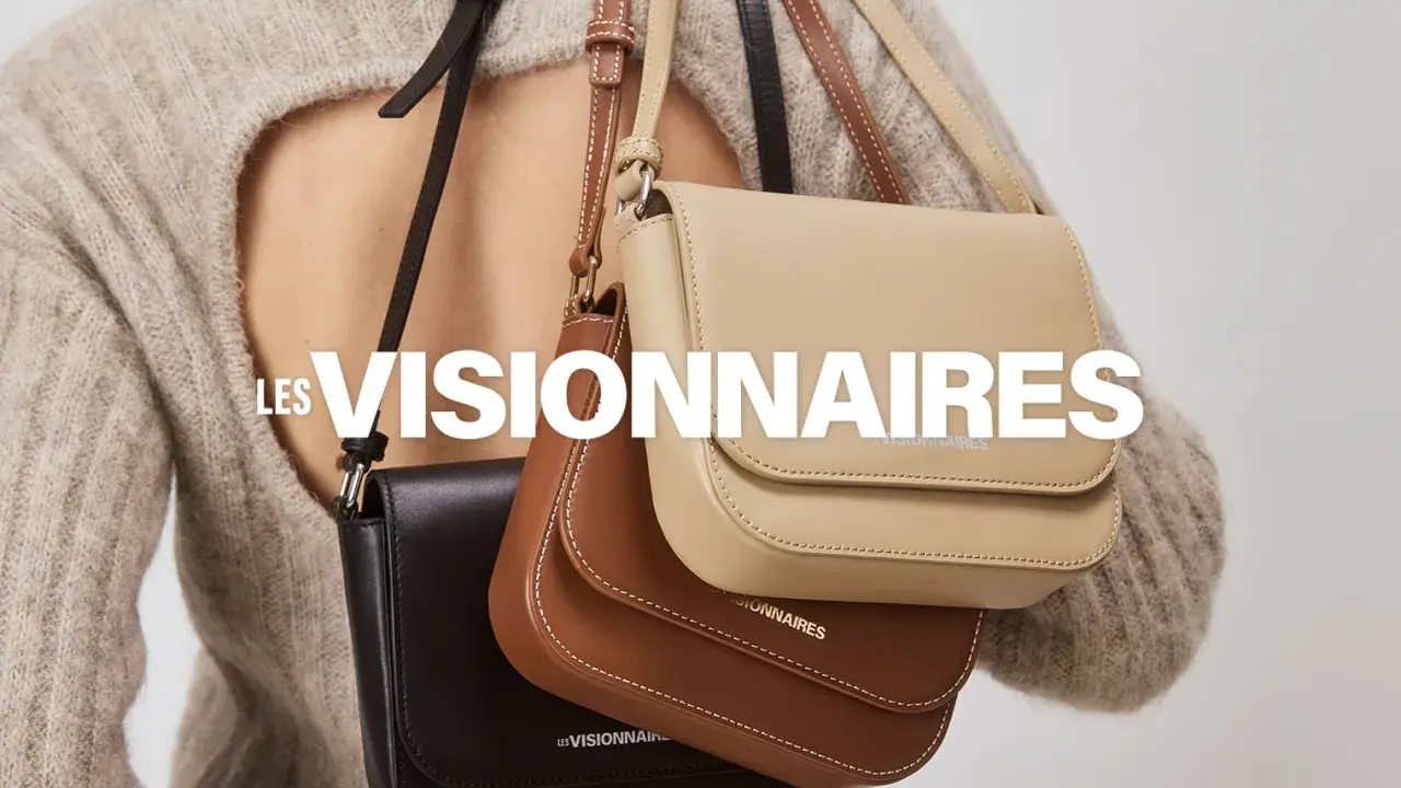 Drei Taschen in Schwarz, Braun und Beige hängen über der Schulter einer Person. LES VISIONNAIRES.