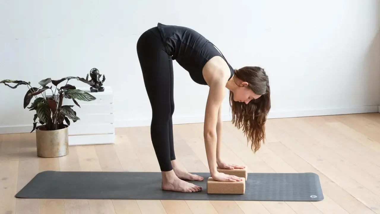 Frau macht Yoga mit Block, um ihre Dehnung zu vertiefen.