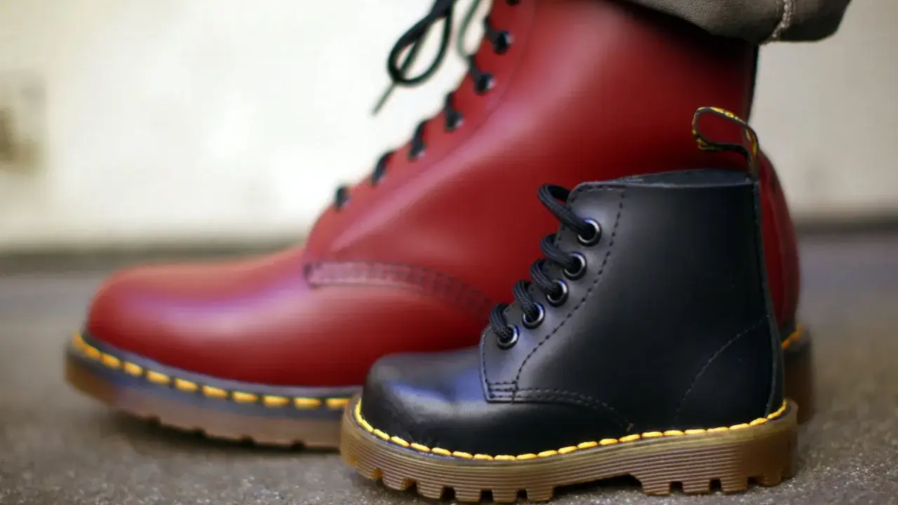 Zwei Dr. Martens Stiefel, ein roter und ein schwarzer, zeigen die Qualität des Dr. Martens Leder.