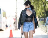 Stylisches Outfit: schwarzes Spitzen-Body, Jeans-Shorts, Lederjacke. Perfekt, um den Look für eine Party zu kombinieren.