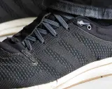 Schuhe binden ohne schleife: Schnürsenkel sind durch Ösen geführt und mit einem Stopper fixiert, was schnelles Anziehen ermöglicht.
