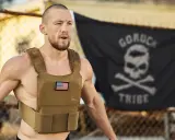 Mann mit Gewichtsweste und GORUCK-Flagge im Hintergrund, bereit für die Murph Challenge.