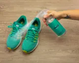 Grüne Nike-Laufschuhe werden mit einem Spray besprüht, um zu verhindern, dass die schuhe stinken. Was tun?