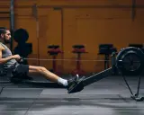 Mann auf Rudergerät, trainiert intensiv. Rudern ist ideal für den Kalorienverbrauch und ein Ganzkörpertraining.