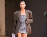 Frau im karierten Blazer und gestreiftem Kleid. Der Blazer muss dringend gewaschen werden, um den Fleck zu entfernen.