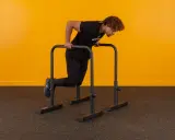 Mann macht Dips an Parallelbarren. Die Frage, wie viele Dips sind gut, hängt vom Trainingsziel ab.