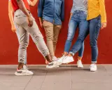Vier Personen mit stylischen Sneakern stoßen ihre Füße aneinander. Perfekt für einen Sneaker-Blog!