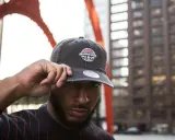 Mann mit Bart hebt seine Kappe, auf der ein Sticker mit "Chicago All-Star Game" prangt. Die neue Ära beginnt, der Sticker bleibt dran.
