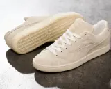 Zwei cremefarbene Puma Wildleder Sneaker, die zeigen, wie fallen Puma Schuhe aus: klassisch und bequem.