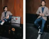 Junger Mann im sportlichen Sakko zur Jeans, sitzt auf einer Truhe neben einem alten Tonbandgerät.