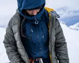 Person in Daunenjacke im Schnee. Tipps zum daunenjacke waschen für optimale Wärme.