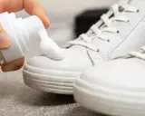 Schaum wird auf weiße Sneaker aufgetragen, um sie sauber zu machen.