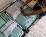 Frau packt ihren Koffer mit Packwürfeln. So packe ich meinen Koffer für die Reise, ordentlich und platzsparend.