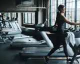 Frau läuft auf Laufband im Fitnessstudio. Ein Laufband bringt Ausdauer und Fitness.