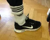 Schwarzer Nike-Schuh mit weißen Streifen an den Socken, die über den Knöchel reichen.