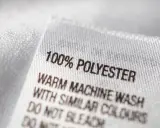 Etikett zeigt "100% POLYESTER". Pflegehinweise für das pflegeleichte Polyester-Material.
