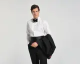 Mann im Smoking mit Fliege und Kummerbund, bereit für den black tie dresscode herren.