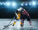 Zwei Eishockeyspieler im Kampf um den Puck. Perfekt, um zu sehen, was anziehen zum Eishockey gucken: warme Kleidung und gute Laune!