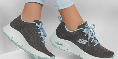 Graue Skechers-Sneaker mit hellblauen Schnürsenkeln und mintgrünen Akzenten. Die Sohlen zeigen die Skechers Sohlen Unterschiede, mit einer markanten ArchFit-Technologie.