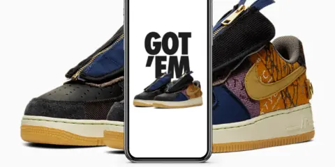 Ein Handy zeigt "GOT 'EM" über einem Paar Travis Scott Air Force 1. Das ist, was ist ein raffle, wenn man diese begehrten Sneaker ergattert!