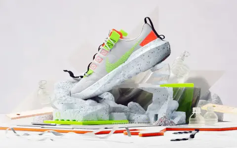 Nike Move to Zero: Ein weißer Schuh mit neongrünen Akzenten, der auf einer skulpturalen Basis aus recyceltem Material steht.