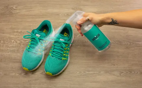 Grüne Nike-Laufschuhe werden mit einem Spray besprüht, um zu verhindern, dass die schuhe stinken. Was tun?