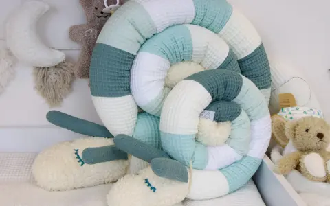 Ein kuscheliger Schnecken-Nestchen für das Babybett. Der cord waschen ist weich und in beruhigenden Pastelltönen gehalten.