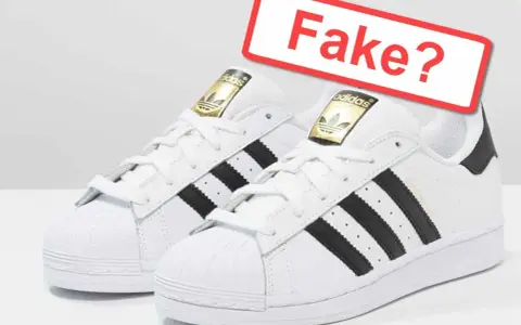 Zwei weiße Adidas Superstar Sneaker mit schwarzen Streifen. Ein rotes Schild fragt: "Fake?". So kannst du Adidas fake erkennen.