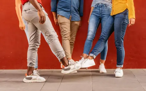 Vier Personen mit stylischen Sneakern stoßen ihre Füße aneinander. Perfekt für einen Sneaker-Blog!