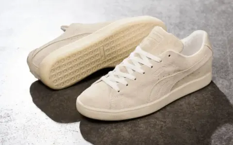 Zwei cremefarbene Puma Wildleder Sneaker, die zeigen, wie fallen Puma Schuhe aus: klassisch und bequem.
