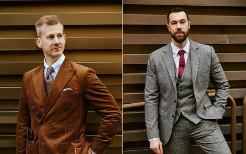 Zwei Männer in eleganten Anzügen. Links ein Mann im braunen Cord-Sakko mit breitem Anzug Revers, rechts ein Mann im grauen Tweed-Anzug mit Weste.
