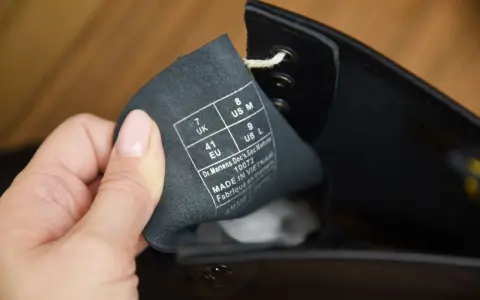 Etikett in einem schwarzen Dr. Martens Schuh zeigt Größenangaben (UK 7, EU 41, US M 8, US L 9) und "Made in Vietnam". So erkennst du Dr. Martens original.
