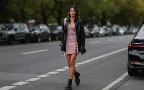 Frauen Dr. Martens richtig tragen: Ein stylisches Outfit mit rosa Kleid, Lederjacke und den ikonischen Boots.