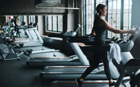 Frau läuft auf Laufband im Fitnessstudio. Ein Laufband bringt Ausdauer und Fitness.