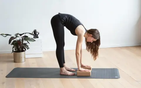 Frau macht Yoga mit Block, um ihre Dehnung zu vertiefen.