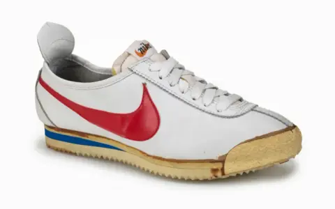 Der erste Nike Schuh von 1972, ein weißer Cortez mit rotem Swoosh und blauer Zwischensohle, ein Meilenstein des Sportschuhdesigns.