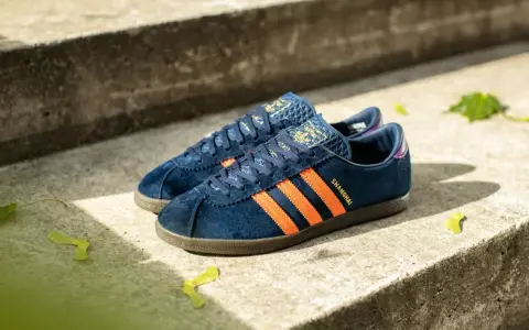 Adidas City Series: dunkelblaue Sneaker mit orangefarbenen Streifen und "Shanghai"-Schriftzug, perfekt für urbane Entdecker.