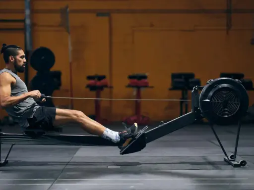 Mann auf Rudergerät, trainiert intensiv. Rudern ist ideal für den Kalorienverbrauch und ein Ganzkörpertraining.