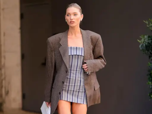 Frau im karierten Blazer und gestreiftem Kleid. Der Blazer muss dringend gewaschen werden, um den Fleck zu entfernen.