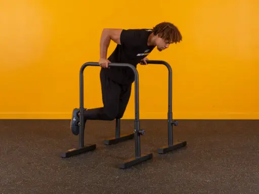 Mann macht Dips an Parallelbarren. Die Frage, wie viele Dips sind gut, hängt vom Trainingsziel ab.