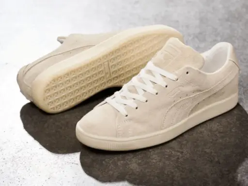 Zwei cremefarbene Puma Wildleder Sneaker, die zeigen, wie fallen Puma Schuhe aus: klassisch und bequem.