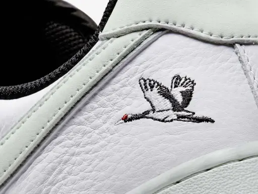 Detailaufnahme eines weißen Sneakers mit Stickerei eines Kranichs. Ein beliebter Schuh, der zu den meistverkauften Sneakern zählt.