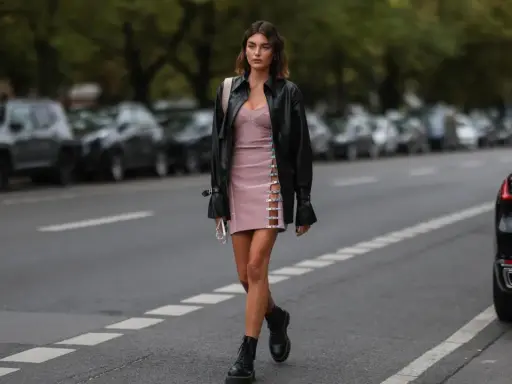 Frauen Dr. Martens richtig tragen: Ein stylisches Outfit mit rosa Kleid, Lederjacke und den ikonischen Boots.